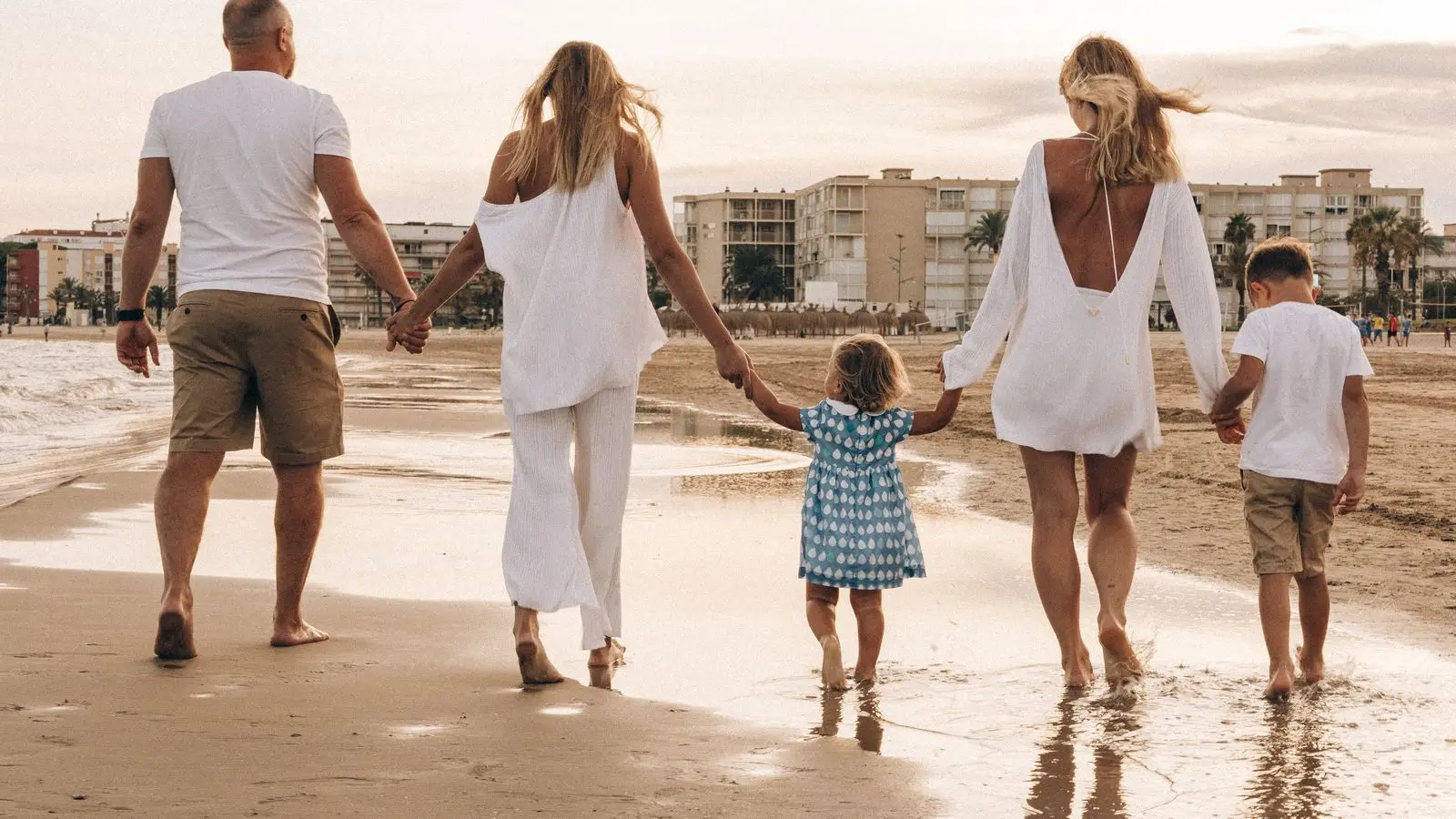 Familia jugando en la orilla de una playa de arena dorada en Orihuela Costa, cerca de Villamartín